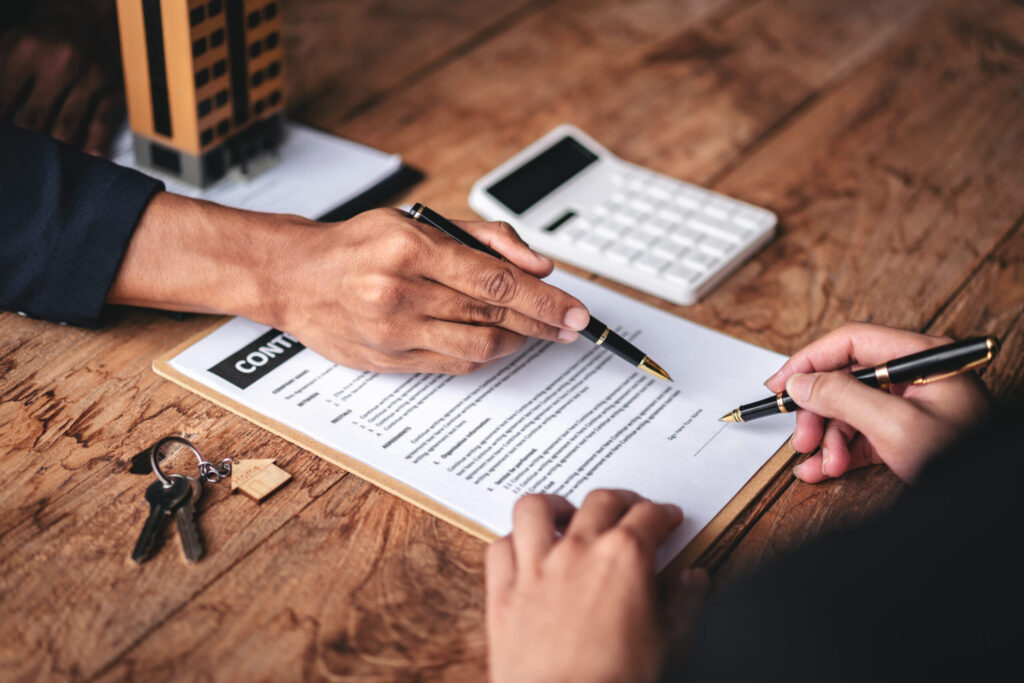 Understanding Initial Costs: Shiki-kin, Rei-kin & Guarantors two people are signing a contract on a wooden table