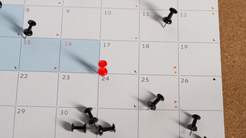 Understanding Your Japanese Payslip: Salary Deductions Explained paper calendar pinned on corkboard with thumbtacks highlighting specific dates for appointments