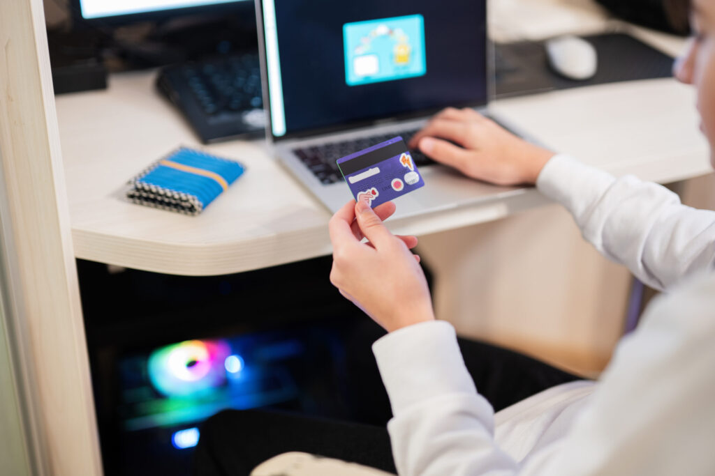 Sending Money Home from Japan: International Money Transfer Options happy teenage boy using laptop and credit card, sitting at desk