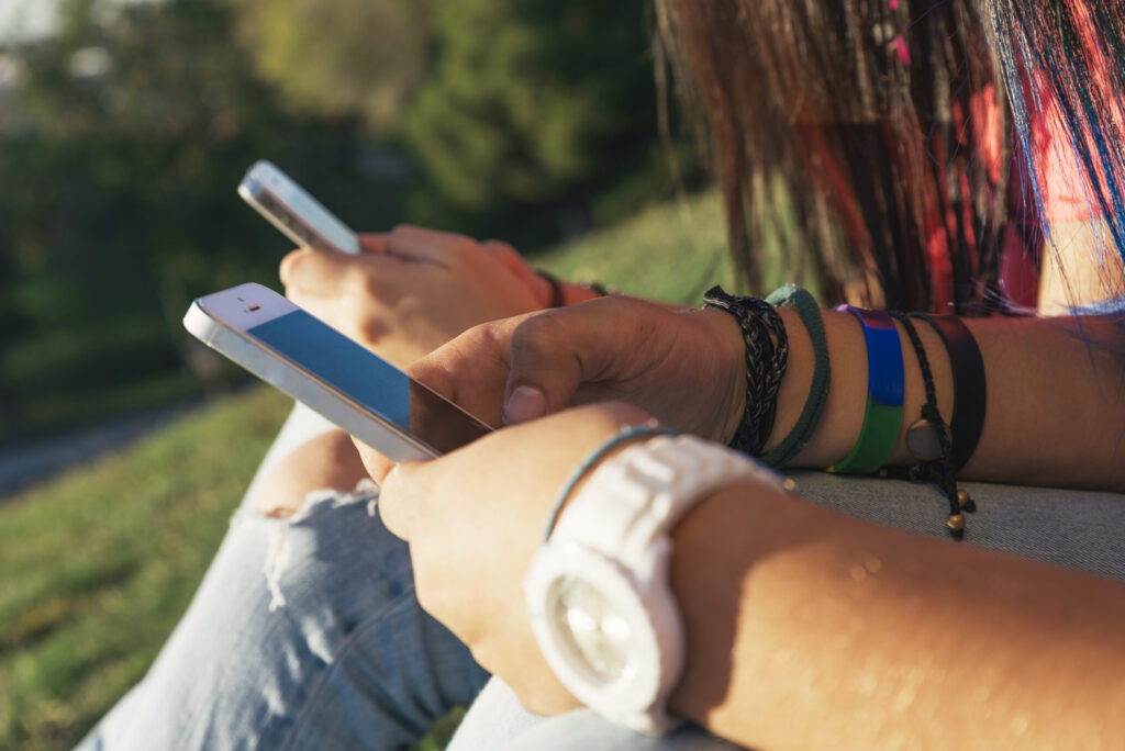 two friend hands texting in their smartphones