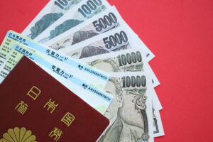 green residence card of japan with passport and japanese yen money on red background